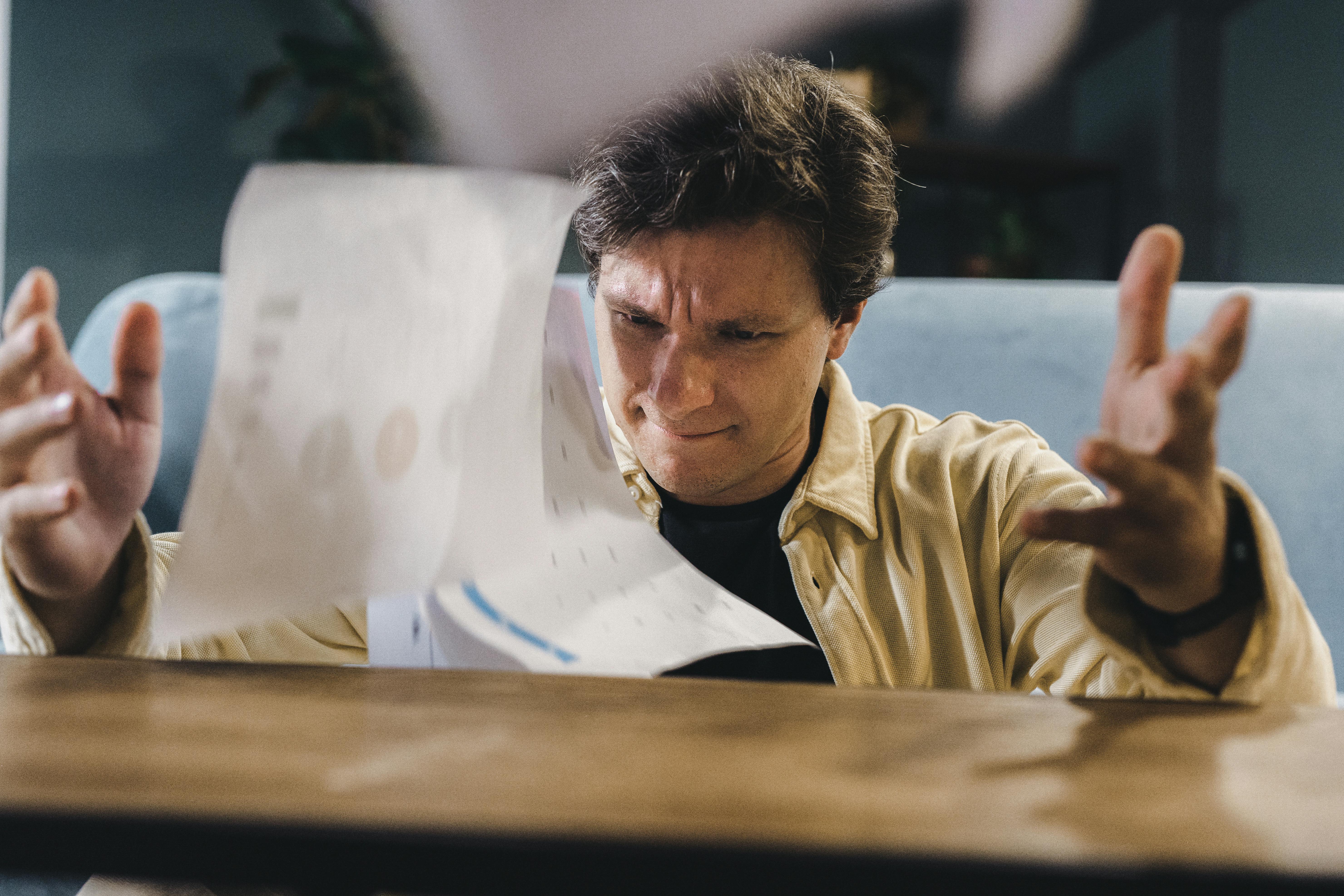 Stressed business owner overwhelmed by paperwork — illustrating lost time and missed enquiries from an outdated online presence